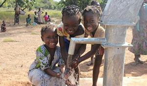 Girls play in clean, safe water from a new well in Burkina Faso.